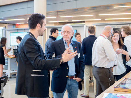 DIEGO TREVINO, senior financing and marketing student, talks to JAVIER SMITH , local San Antonian businessman at the Stumberg Competition.   Photo by Claudia Garcia 